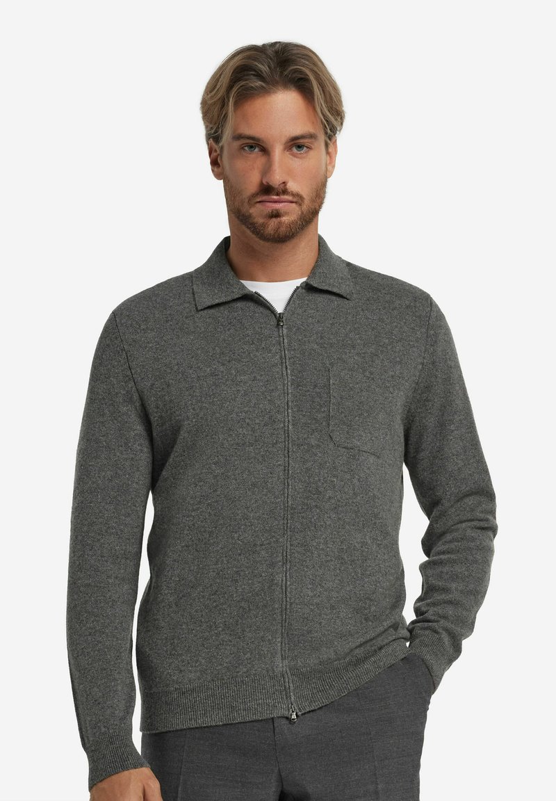 Grauer Reißverschluss-Cardigan aus weichem Strick mit geripptem Saum, Kragen-Design und Brusttasche. Mit langen Ärmeln und einem schlichten, modernen Schnitt.