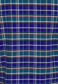 Tissu à carreaux présentant des motifs bleus, verts et blancs avec des accents rouges et noirs ; texture lisse avec une disposition en grille régulière.