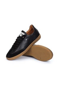 Baskets en cuir noir avec un nez en daim texturé, design à lacets, intérieur tan et semelle en caoutchouc gomme. Présente de petites perforations sur les côtés.