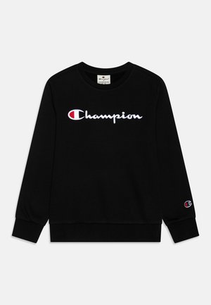 Sudadera negra de mangas largas, con un logotipo blanco bordado de "Champion" en el pecho y un pequeño logotipo en la manga derecha.