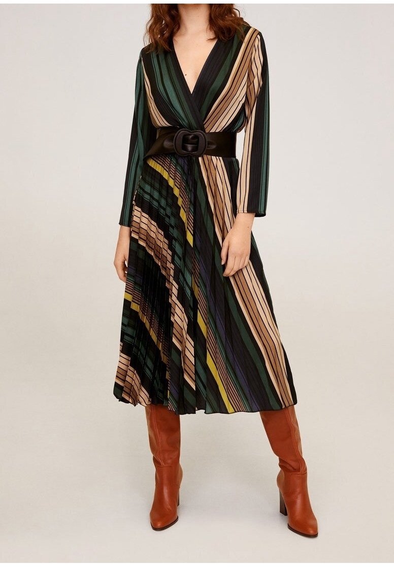 Femme portant une robe midi rayée à manches longues avec une ceinture noire et des bottes marron hautes à talons, sur un fond uni.