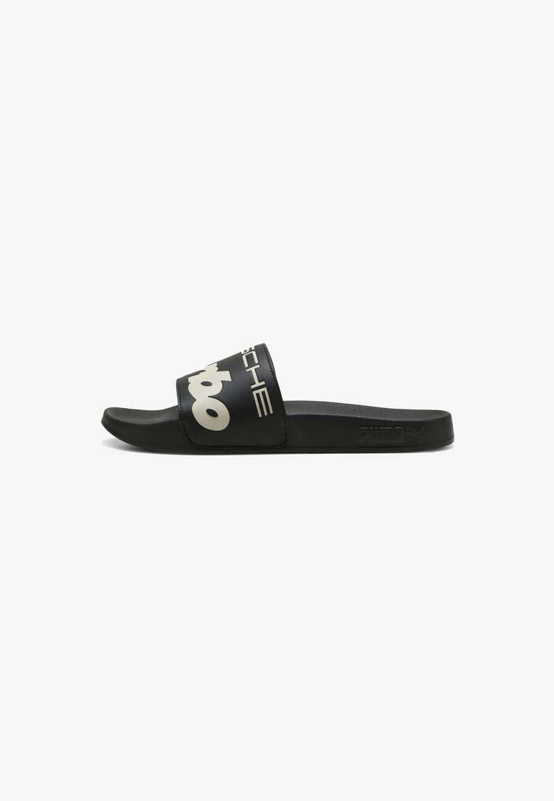 Infradito neri con una fascia larga che presenta un testo logo bianco. Realizzati in materiale sintetico, con una soletta testurizzata e una suola piatta.