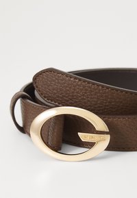 Brown leather belt featuring a smooth, textured surface and a gold oval buckle with the brand name embossed.