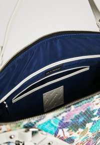Wielokolorowa torebka z textured zewnętrzną stroną, z niebieskim satynowym wnętrzem, wieloma kieszeniami i srebrnym zamknięciem na zamek.