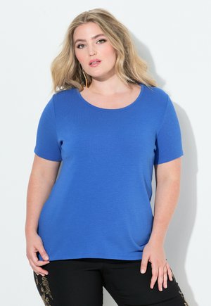 Kongelig blå kortærmet t-shirt med rund halsudskæring, glat tekstur og afslappet pasform, parret med sorte bukser med guld accenter.