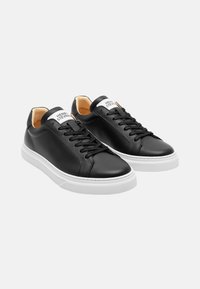 Schwarze Leder-Sneaker mit weißen Gummisohlen, runder Zehenpartie und schwarzen Schnürsenkeln. Mit einem weißen Etikett auf der Zunge mit dem Markennamen.