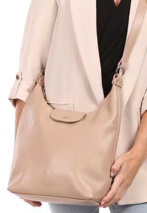 Beige leren handtas met een textuurafwerking, een ronde vorm, een verstelbare schouderband en een flap met een klein logo-detail.