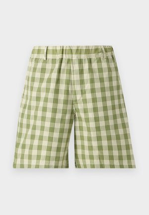 Zöld kockás rövidnadrág, könnyű anyagból készült, gumis derékkal és oldalsó zsebekkel. A kockás minta világos és sötét zöld színekben váltakozik.