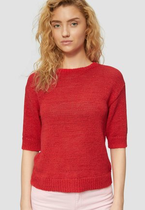 Roter Strickpullover mit kurzen Ärmeln, Rundhalsausschnitt und gerippten Abschlüssen am Ausschnitt und Saum. Die Textur wirkt weich und der Schnitt ist locker.