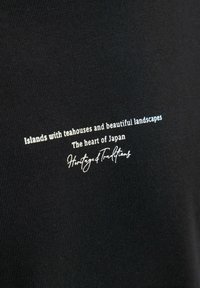Melna auduma ar baltiem un sudraba burtiem: "Salas ar tējnīcām un skaistiem ainavām. Japānas sirds. Mantojums un tradīcijas."