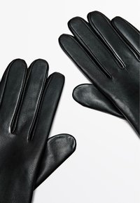 Zwarte leren handschoenen met een gladde textuur, voorzien van vijf verlengde vingers en stikdetails langs de naden.