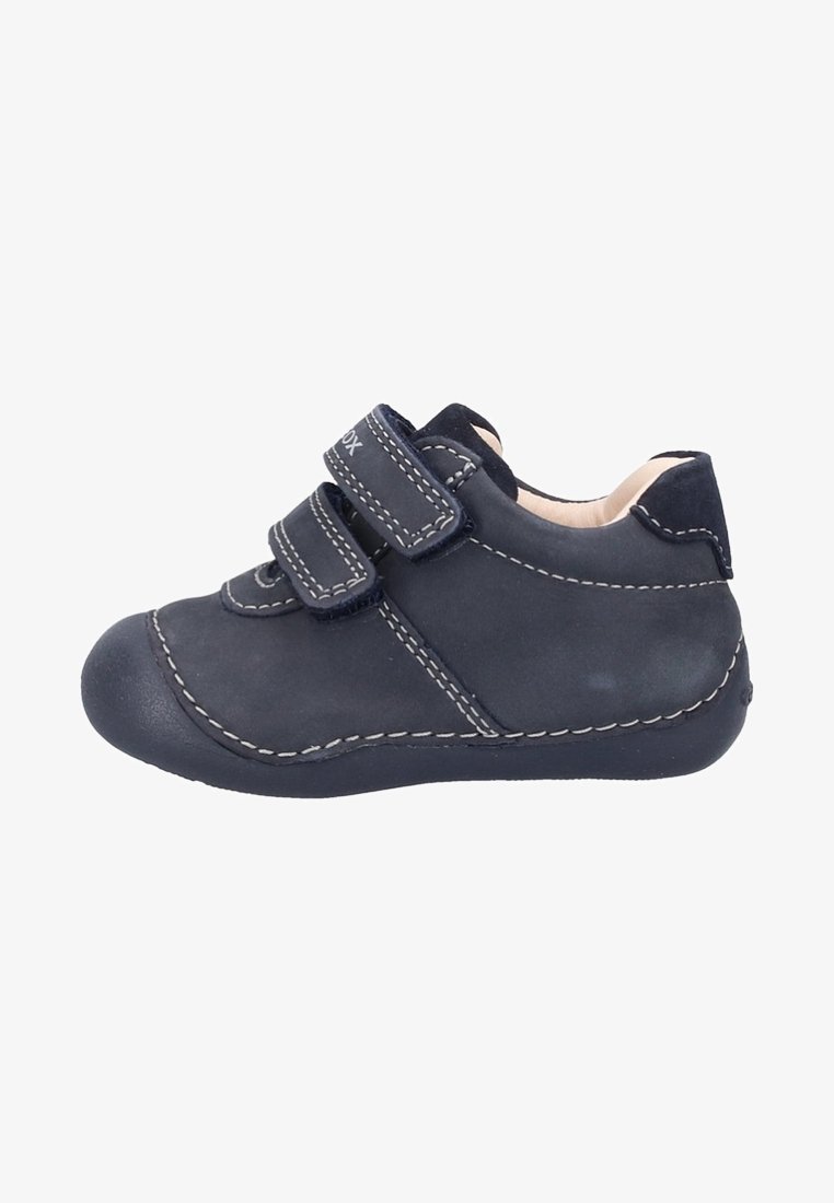 Chaussure en cuir marine pour tout-petit avec deux bandes Velcro, bout arrondi, coutures blanches contrastantes et une finition douce et texturée.
