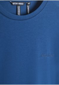 T-shirt blu a girocollo con piccolo logo ricamato "Antony Morato" sul petto e etichette visibili all'collo.