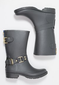 Botas de goma grises con un acabado brillante, hebillas de hardware dorado y una textura suave; presentan un tacón bajo y acentos de correas.