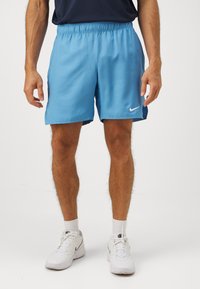 Gaiši zili sporta šorti, izgatavoti no gludas auduma ar elastīgu jostu. Saturs neliels balts Nike logo apakšējā labajā pusē.
