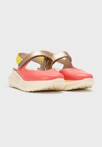 Sandalias de color coral y dorado metálico con un acento amarillo, que cuentan con una suela blanca gruesa y correas ajustables. Textura suave y diseño abierto.