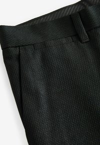 Schwarze, maßgeschneiderte Hose aus einem strukturierten Stoff mit einem dezenten Streifenmuster, flachem Vorderteil und glattem Bund.