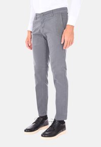 Chinos grigi in tessuto misto cotone, con vestibilità slim, davanti piatto e due tasche laterali, abbinati a scarpe nere stringate.