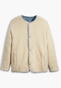 Fleece bunda v krémové barvě s hladkým denimu, kulatým výstřihem, cvokovými knoflíky a dvěma bočními kapsami. Měkký, texturovaný povrch.
