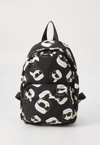 Black backpack featuring a repeating pattern of stylized white-haired figures wearing sunglasses, with adjustable straps and a zip closure.