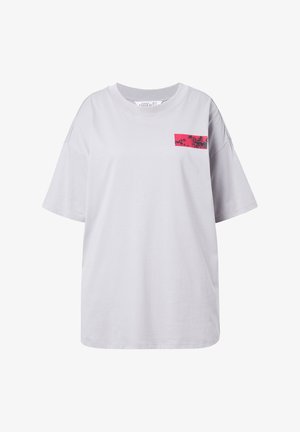 T-shirt surdimensionné gris clair en coton avec un col rond. Présente un graphique rectangulaire rose avec des silhouettes de palmiers et le texte "PLAGE".