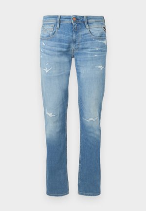 Jean slim bleu clair avec légère décoloration sur les cuisses et les genoux, doté de cinq poches et d'une fermeture à bouton.