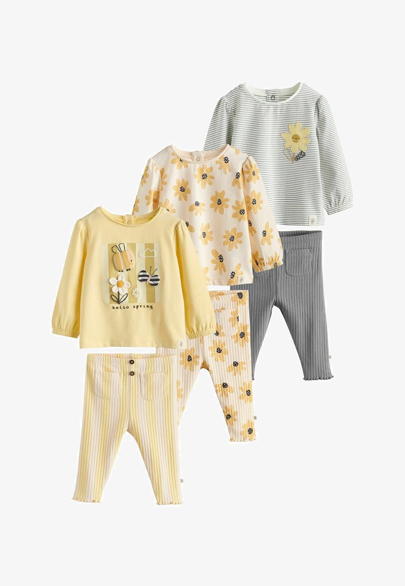 Drie setjes babykleding met longsleeves en geribbelde broekjes in geel, wit met gele bloemen en gestreept grijs met bloemdetaillering.