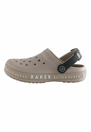Light brown slip-on clog with ventilation holes, black adjustable heel strap, and "Baker by Ted Baker" branding on sole and strap.