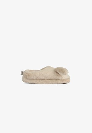 Valkoinen pörröinen tossu, jossa on pehmeä ja ylellinen pinta, pyöreä muoto sekä koristeellinen pom-pom varpaassa. Hienovarainen brändilogo sivussa.