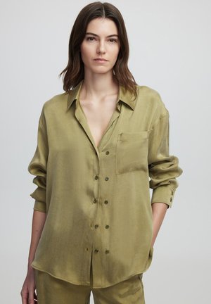 Camicia verde oliva con bottoni realizzata in tessuto leggero. Presenta una tasca sul petto, maniche lunghe e una vestibilità rilassata con una texture morbida.