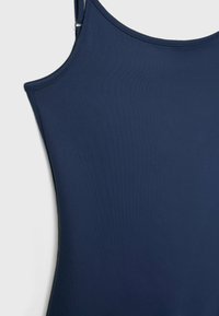 Maillot de bain bleu marine sans manches avec fines bretelles et tissu lisse, présenté sur un fond clair uni.