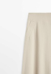Jupe en laine beige avec un détail de poche rectangulaire à l'avant, présentée sur un fond blanc.