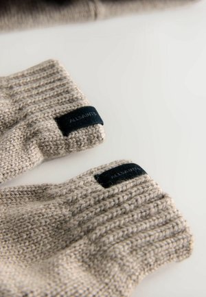 Beige strikkede handsker med ribbet tekstur og sort vævet mærke, der viser "ALLSAINTS" på kanten. Stoffet er blødt og lidt fuzzy.