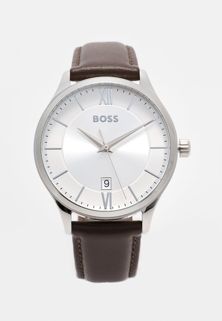 Silberne analoge Uhr mit Zifferblatt in rund, ausgestattet mit einem weißen Ziffernblatt, schwarzen römischen Ziffern, Datumsanzeige und einem braunen Lederarmband.