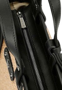 Borsa in pelle nera con dettagli in paglia intrecciata, dotata di chiusura con zipper e hardware in metallo elegante per un design moderno.