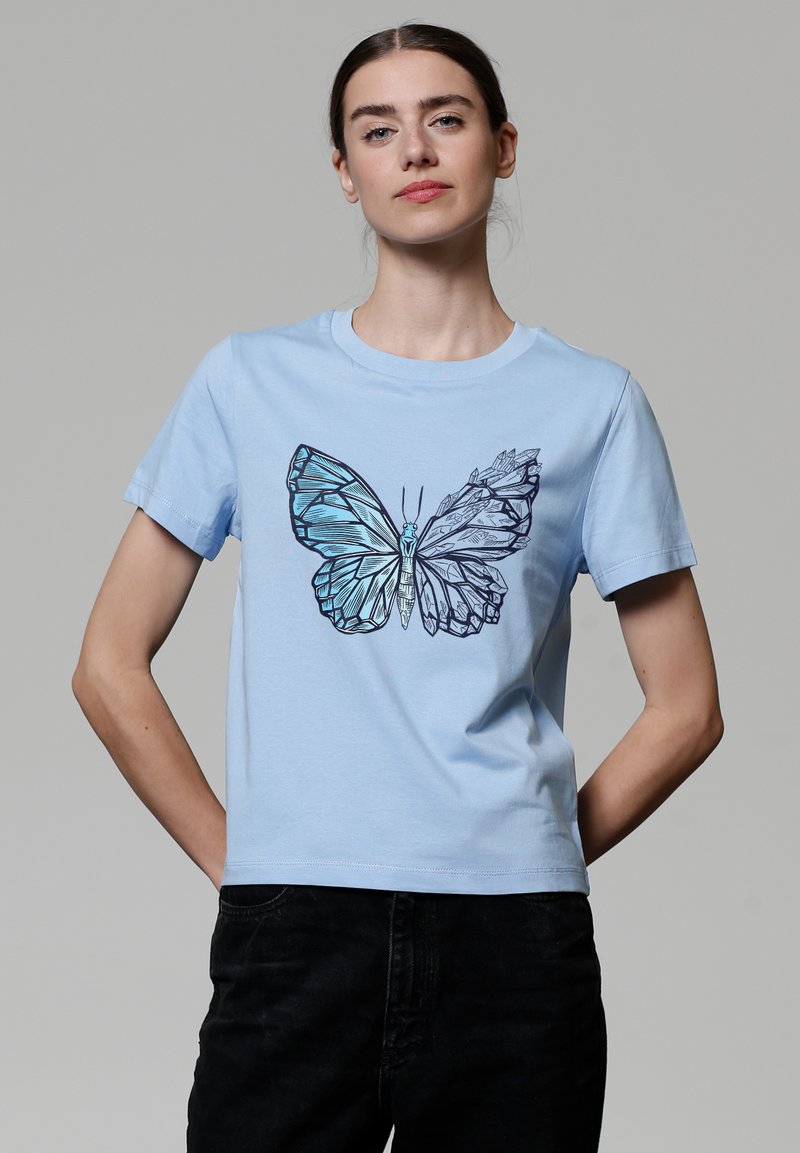 Helles blaues T-Shirt mit einem großen Schmetterlingsgrafik in Schwarz und Blautönen, kurzen Ärmeln und einem runden Halsausschnitt.