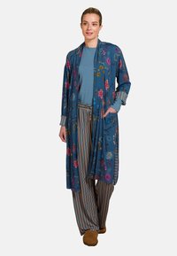 Blauwe bloemenkimono van een lichtgewicht stof, met gekleurde bloemen, lange mouwen, een open front en zijzakken. Gecombineerd met gestreepte broek.