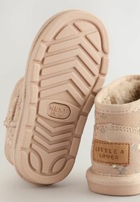 Stivaletto per bambini di colore rosa chiaro con motivo floreale, suola in gomma con battistrada a zigzag e texture simile alla suede. Etichetta con la scritta "LITTLE & LOVED."