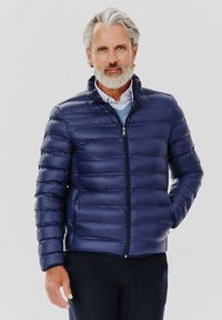 Granatowa kurtka puchowa z poziomym pikowaniem, wysokim kołnierzem i zapięciem na zamek, wykonana z błyszczącego, lekkiego materiału.