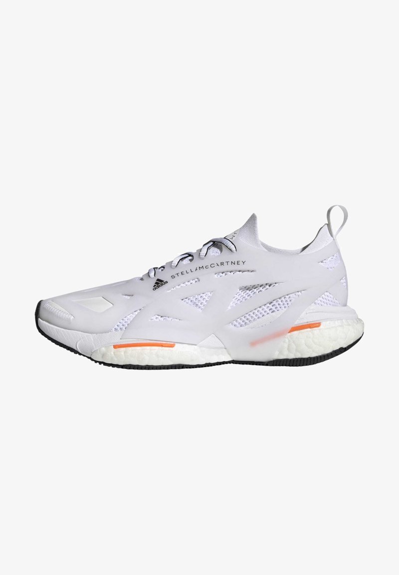 Bílé sportovní boty s prodyšnou síťovinou, kontrastní černou podrážkou a oranžovým akcentem na boku. Mají elegantní, zaoblený design.