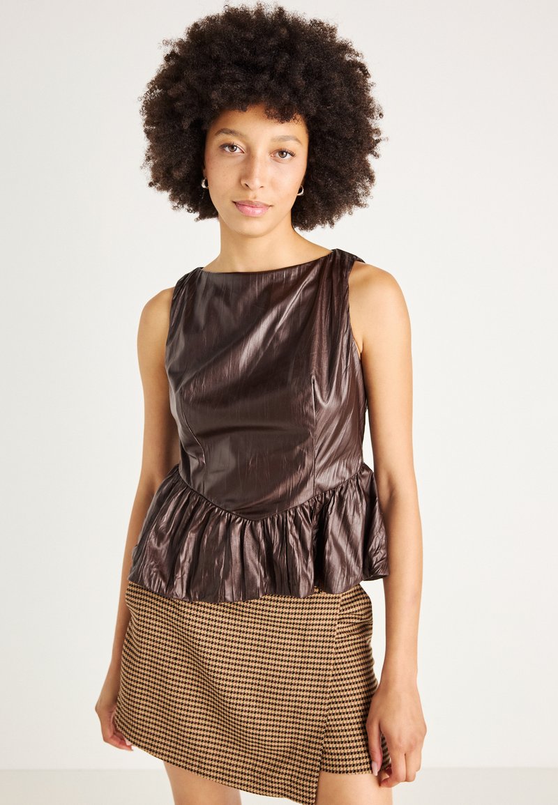 Hnedý peplum top vyrobený z lesklého materiálu, s okrúhlym výstrihom a textúrovaným, volánikovým lemom, v kombinácii s sukňou s károvaným vzorom.