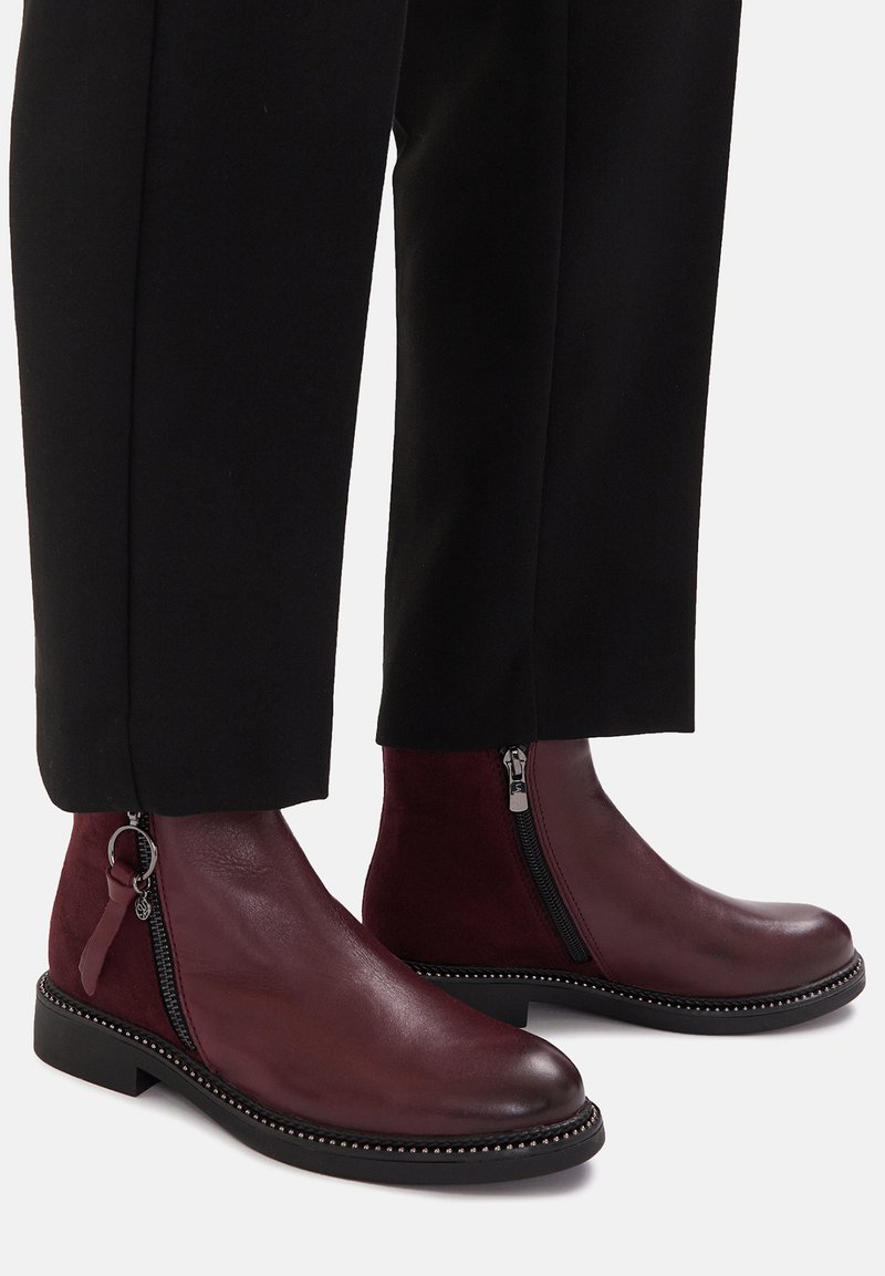 Burgundia nahast ja seemisnahast pahkluu saapad külgseti tõmblukkudega, ümarate ninaosade ja tasase tallaga, mille serval on dekoratiivsed helmed.