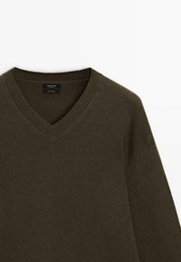 Maglione in cashmere verde oliva scuro con scollatura a V e colletto a costine, realizzato da Massimo Dutti, esposto su uno sfondo bianco.