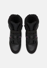 Paire de bottes d'hiver noires avec doublure en fourrure épaisse, languettes rembourrées, bouts ronds et lacets croisés avec de petits détails rouges, blancs et bleus.