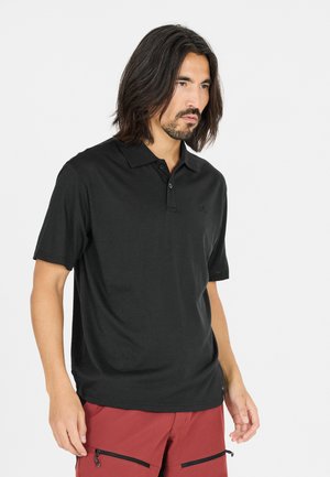Sort polo-shirt lavet af struktureret stof, med en klassisk krave og tre knaplukninger. Diskret logo detaljeret på brystet.