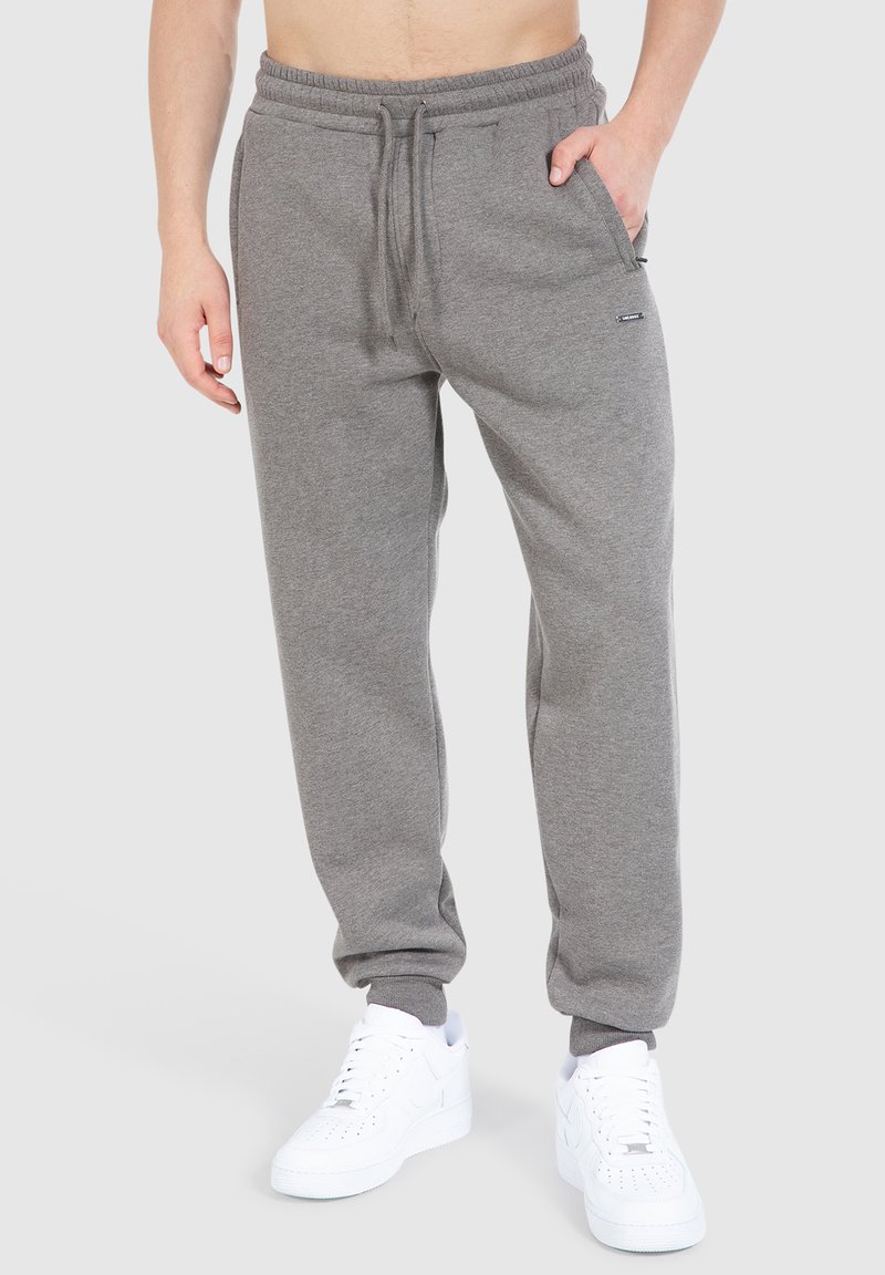 Grijze joggingbroek van een katoenmix. Kenmerkt zich door een elastische tailleband en boorden, voorzakken en een klein merkembleem aan de zijkant.