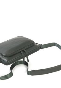 Borsa a tracolla in pelle verde scuro con una texture morbida, scomparti con zip e una tracolla regolabile per un trasporto conveniente.