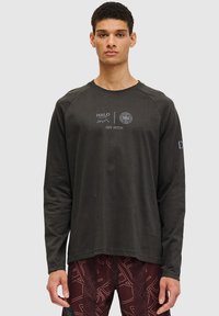 Long-sleeve black t-shirt made of soft fabric featuring white graphic text on the front and a relaxed fit with raglan sleeves.