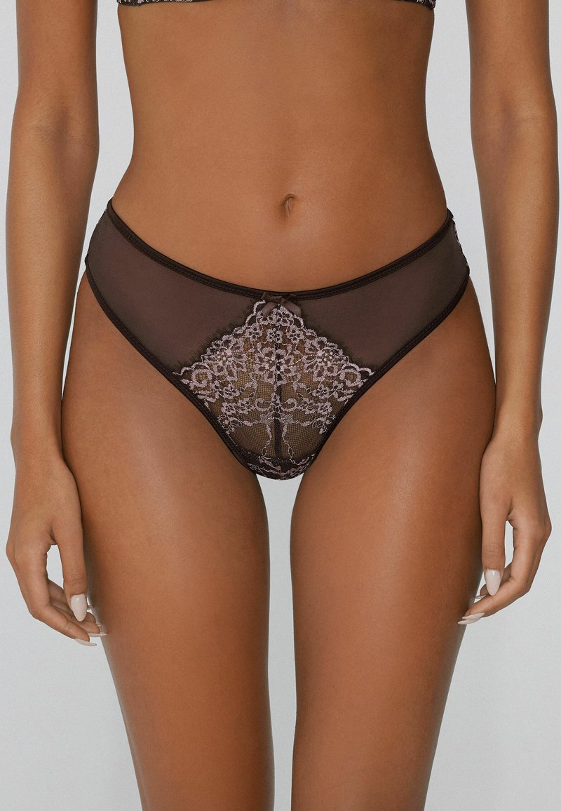 Zwarte netten slipjes met intrikate lila kant ontwerpen in een diamantvorm, met een klein strikdetail in het midden en contrasterende bies.