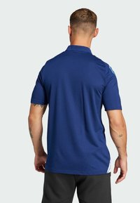 Marineblaue Poloshirt aus strukturiertem Stoff, mit kurzen Ärmeln und klassischem Kragen. Enthält hellblaue Akzente an den Schultern.